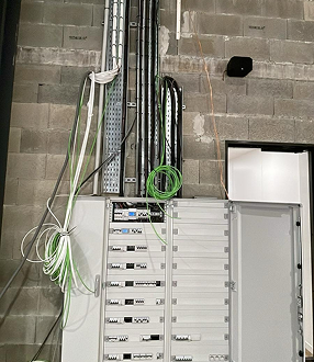 Armoire électrique avec câbles apparents et équipements techniques